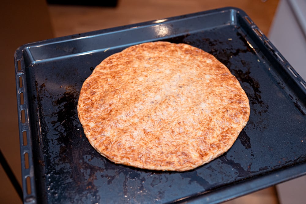 Kesopizza skuren i bitar med mozzarella och ruccola